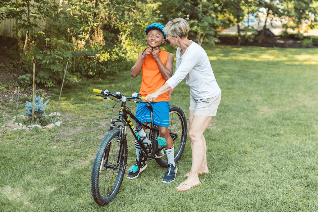 Mãe ensinando seu filho a andar de bicicleta.