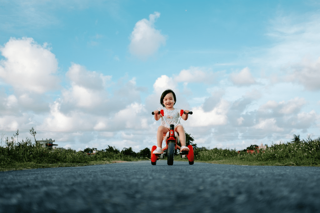 Menina jovem andando em uma bicicleta vermelha